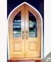 G114ATG Gothic arch double entrance door unit in 100% solid Red oak. Shown with applied moldings, raised panels and clear insulated glass.